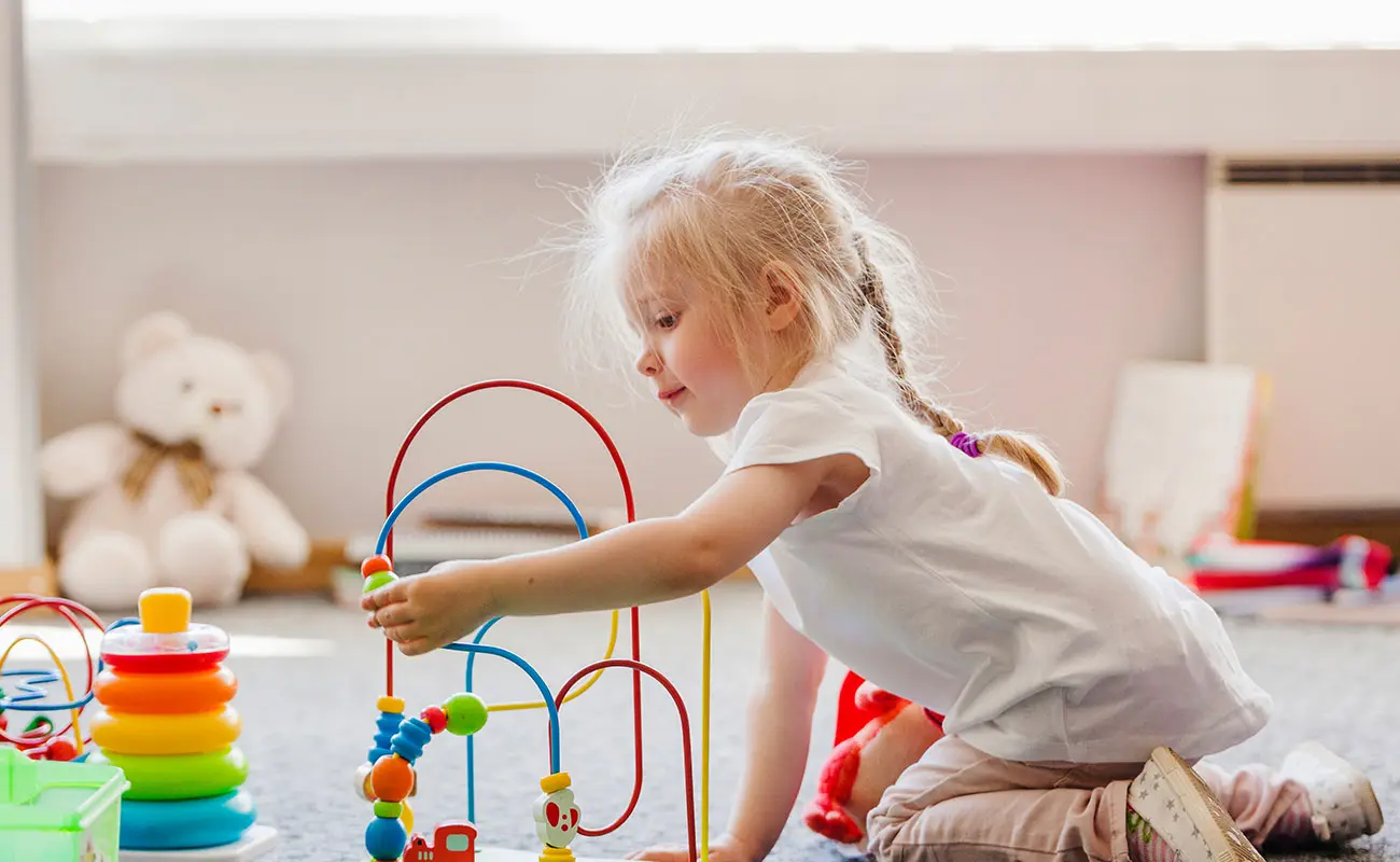 Petite fille jouant seule avec un jouet, heureuse