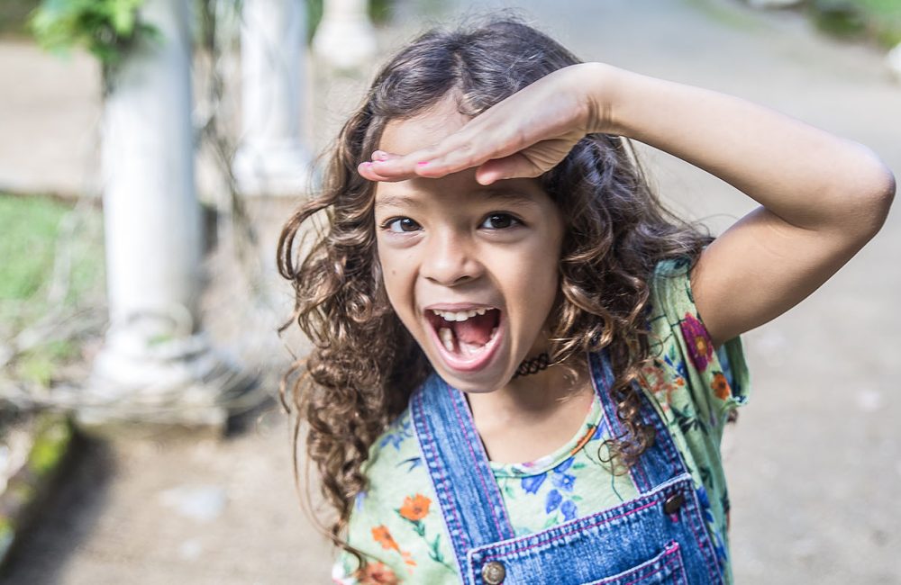 Fille joyeuse faisant un geste de salut vers la caméra