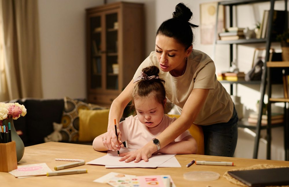 Une mère enseigne à sa petite fille autiste à dessiner.